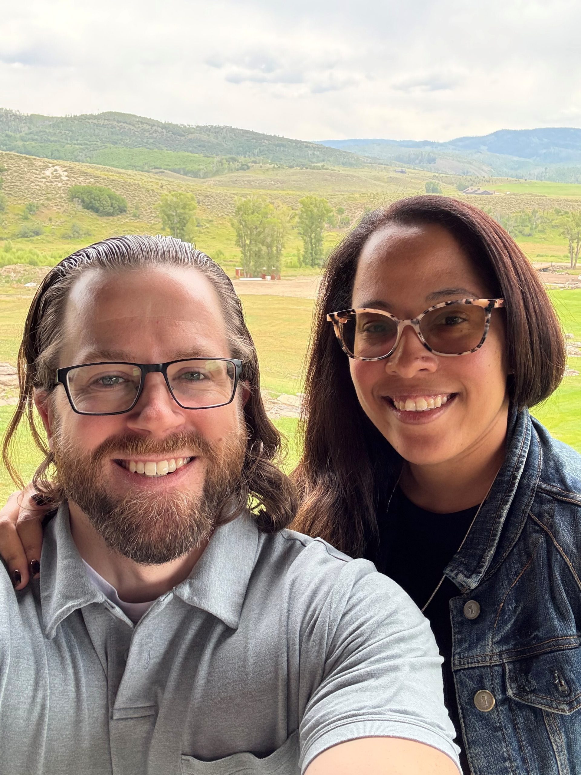 Nick Dunlap in selfie with his wife with mountain range in the background.
